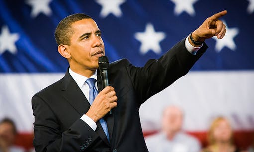 Barack Obama speaking at even with American flag in background