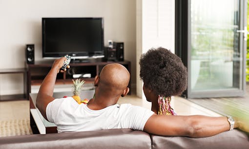 A couple sitting on the couch watching television