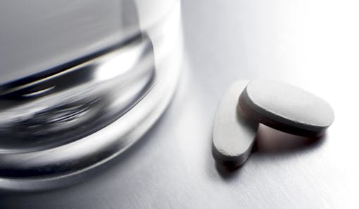 Glass of water and two pills