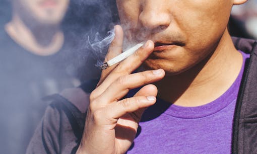 Man smoking cannabis joint outdoors