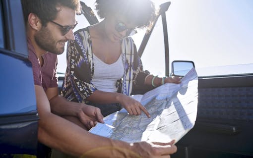 Couple on a road trip checking their map