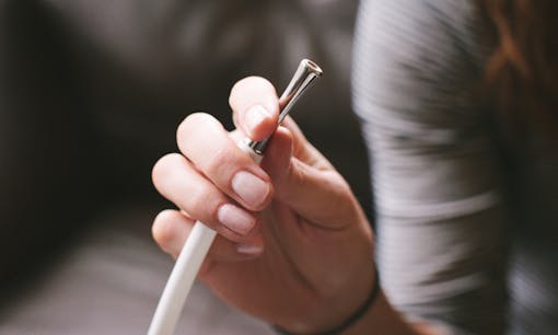 Woman holding Herbalizer table-top vaporizer tube