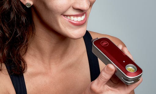 Woman smiling and holding Firefly2 cannabis flower vaporizer