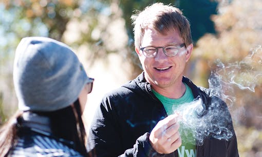 A man and a woman sharing a cannabis joint