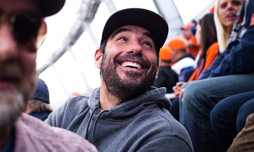 Former NFL player Nate Jackson laughing with friends at the Denver Broncos game with Leafly