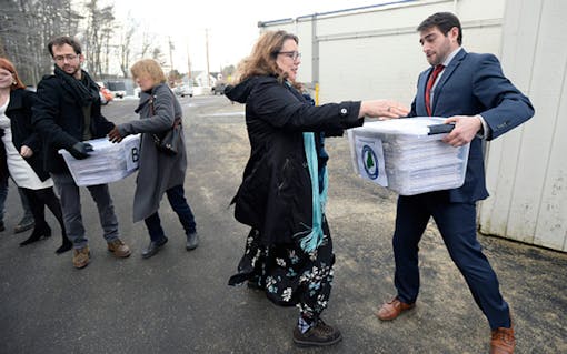 Campaign manager David Boyer passes a box of petitions to Rep. Diane Russell from Portland on Feb. 1, as the Campaign to Regulate Marijuana Like Alcohol prepares to deliver the petitions to Augusta. Photo via Getty