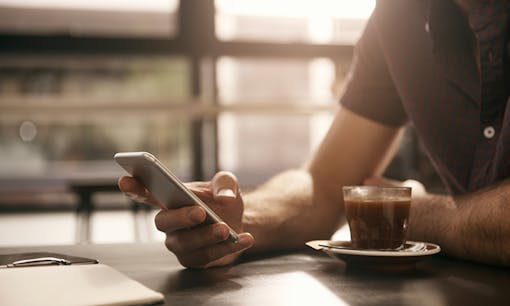 Man holding phone in coffee shop