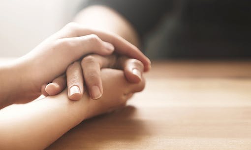 Friends holding hands during times of trouble