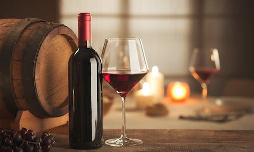 Red wine in bottle next to glass