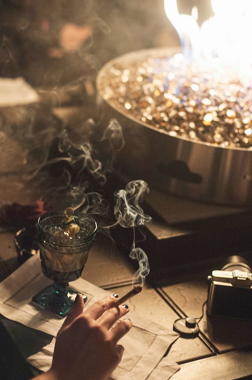 Woman holding lit cannabis joint at Mason Jar Event Group's winter cannabis-paired dinner