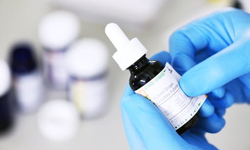 A person wearing sterile medical gloves handling Tilray cannabis extract packaging