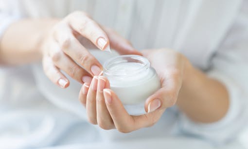 Woman holding cannabis topical lotion container