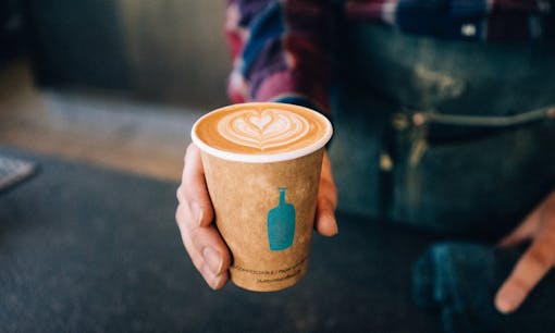 Man holding latte from Blue Bottle Coffee