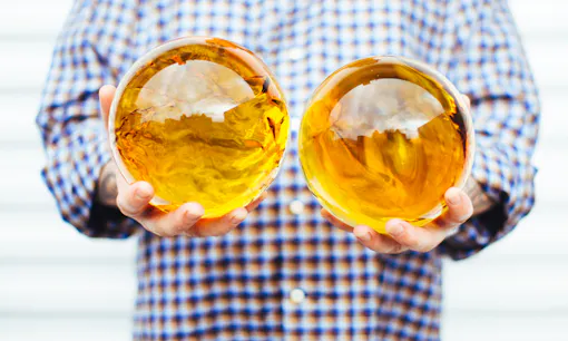 Man holding two "Dragon Balls," each filled with 3,000 grams of cannabis oil