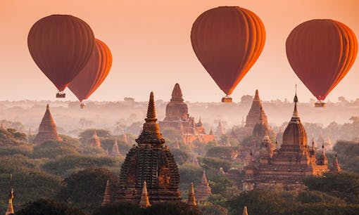 Balloons flying over ruins in Myanmar, Burma, at sunrise