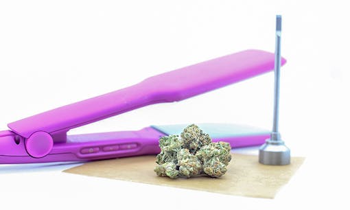 Cannabis flower, straightening iron, and wax paper
