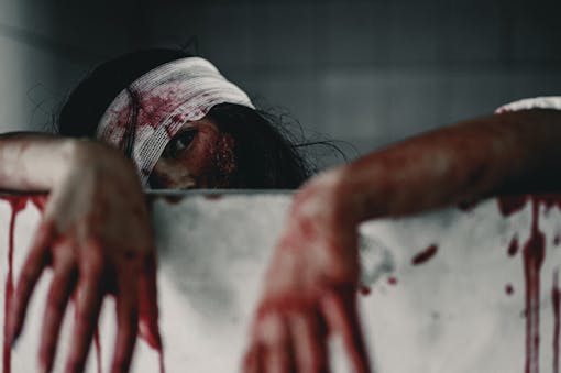 Horror Scene of a Woman bloody hands with resentment torture and ask for help, in abandoned building, Halloween murder concept.