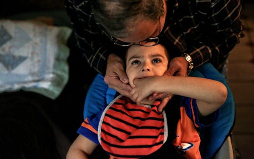 In Delgadillo's home, everyone does their part to take care of Bruno. Here, her stepfather Mario Vallecillo plays with Bruno before helping to get him in the car for therapy in Miami, FL on Friday, October 28, 2016. (Scott McIntyre for Leafly)