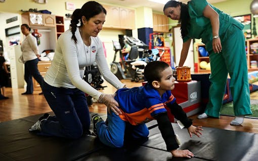 Occupational therapist Erika Bermeo helps to guide Bruno Stillo as he exercises his crawling during a therapy session at B&V Thera-Pro in Miami, FL on Friday, October 28, 2016. Before he began using medical marijuana, Bruno was mostly immobile. Since he started integrating it into his daily medication, his motor skills have improved and his epileptic seizures have drastically decreased. (Scott McIntyre for Leafly)