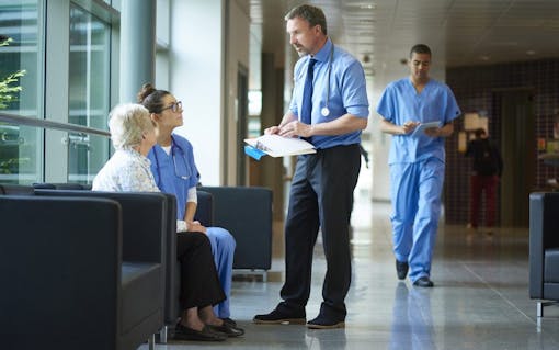 doctor chatting to a patient on the hospital corridor.