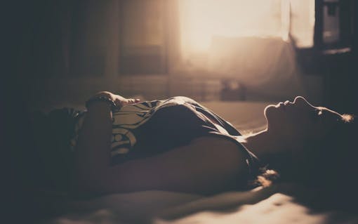 Sad girl lying in bed