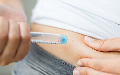 close up of hands making injection by insulin pen