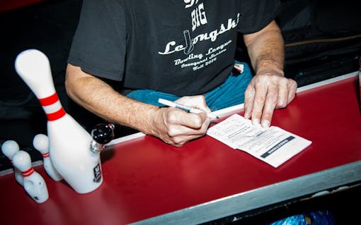 Gary Lane totals the final scores to determine the winner of The Big Lebongski Bowling Tournament in Burbank, CA. (Justin Stewart for Leafly)