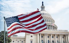 american flag waving in front of US Capitol