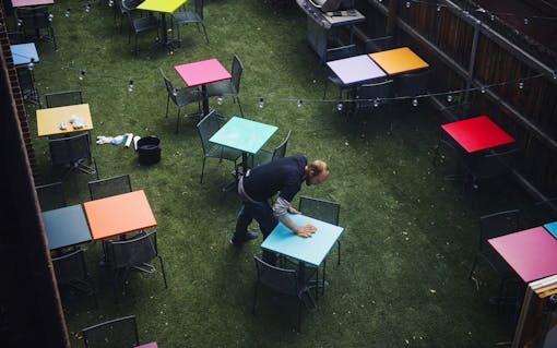 Co-founder Zach Gardner wipes down tables outside on opening day of the International Church of Cannabis (Daniel Brenner for Leafly)