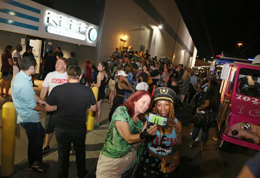 Dawn Weir, center left, interviews customer Candace Foshee, center right, for a cannabis-themed radio show while customers wait in line behind them at The Reef Dispensary. (Ronda Churchill for Leafly)