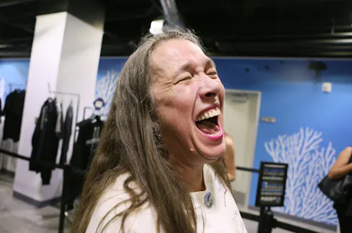 Customer Marilyn Uldricks laughs while speaking to the news media after making a purchase shortly after legal sales began early Saturday morning. (Ronda Churchill for Leafly)