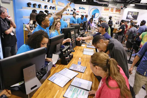 While daytime crowds were a bit smaller on Saturday, long lines of customers kept budtenders scrambling. Here, shortly after midnight, staff members at The Reef Dispensary attend to patrons shortly after the beginning of legal, adult-use sales. (Ronda Churchill for Leafly)