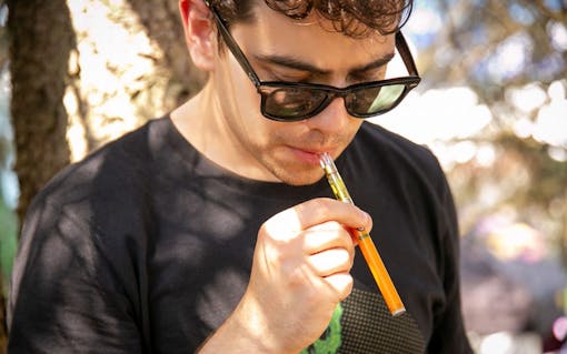 man in sunglasses vaping cannabis oil