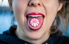 sublingual vs edibles dosing; woman holding candy on tongue
