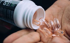 Person shaking Try The CBD capsules into their palm