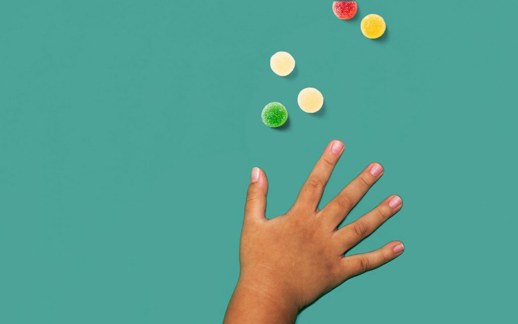 Child's hand reaching for candy;  what happens when kids eat marijuana edibles