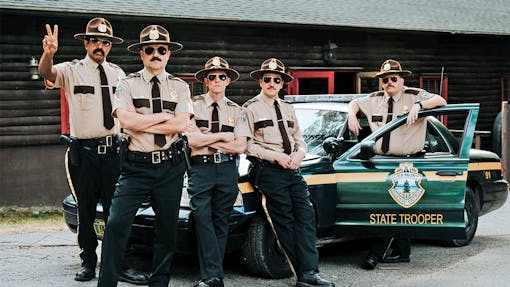 Super Troopers in front of cop car