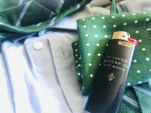 Photo of lighter laying on a tie and button up shirt