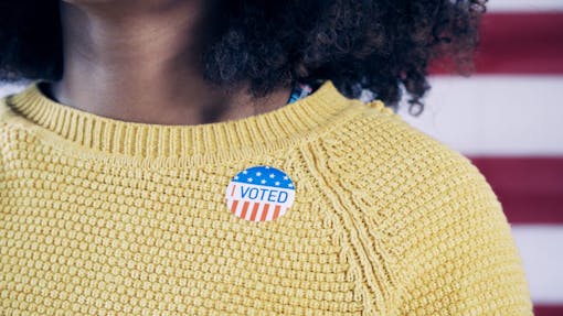 Black woman with I Voted sticker after voting in the 2020 election
