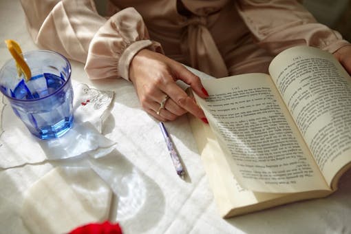 Stylish Woman Smoking a Joint at home while reading.