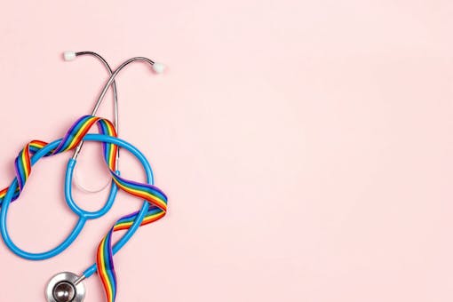 Stethoscope with LGBT rainbow ribbon on pink background