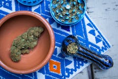 Marijuana in Blue Pipe with Grinder and Bowl of Cannabis (Overhead)