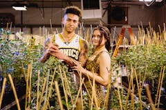 Owners of Magic Hour Cannabis stand in indoor grow room