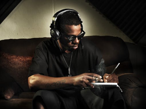 dj writing lyrics on note book in studio