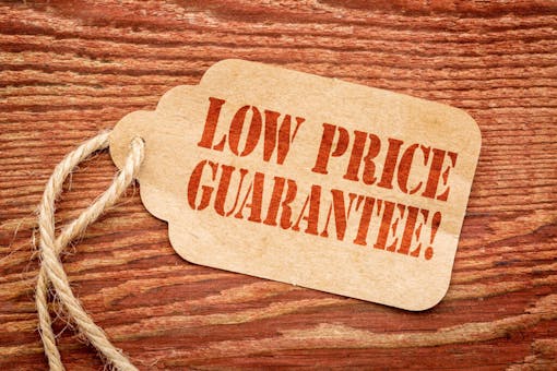 low price guarantee - sign on paper price tag against a rustic barn wood