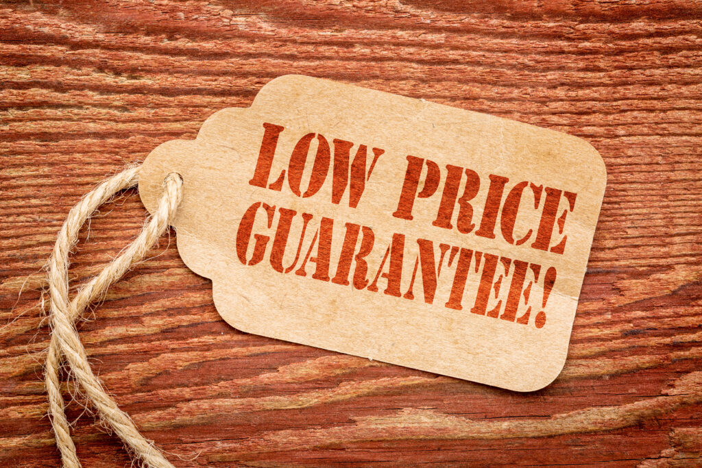 Low price guarantee - sign on paper price sign against rustic barn wood