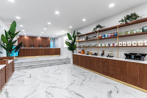 minimalist interior with marble floor and shelves flush into walls with cashier stand at far end