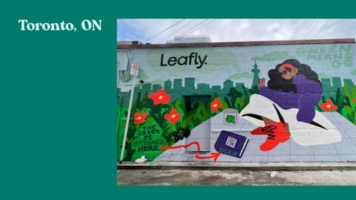 Leafly's 420 mural NFT in Toronto, featuring a woman of color reading a book in a park with the city skyline behind her