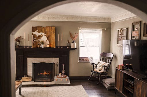 cozy living room with fire in fireplace rocking chair in corner and flat screen TV to the right