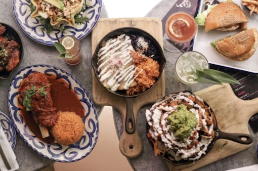 array of Mexican dishes seen from above on table, in plates and in skillets